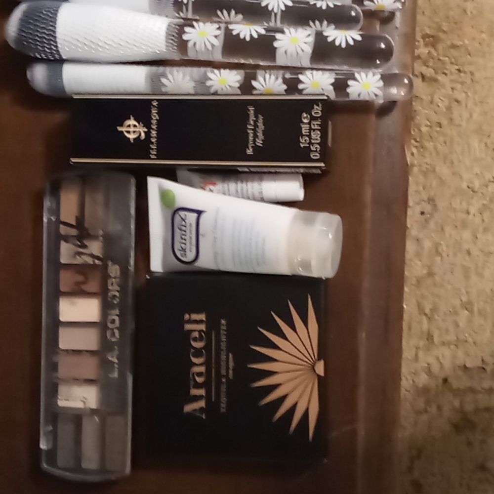Make up eye shadow, cute make up brushes with daises, liquid highlighter, and mo